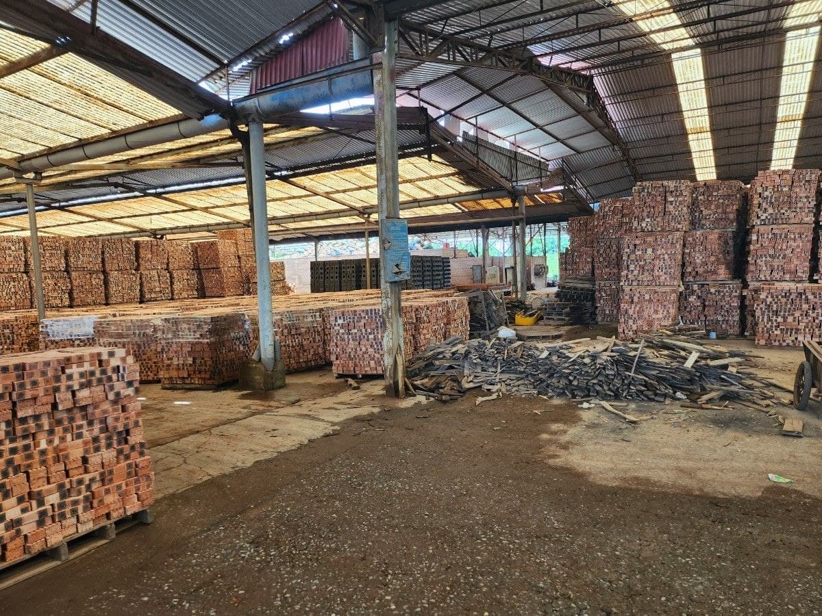 Stored bricks and facility materials inside the covered production area.